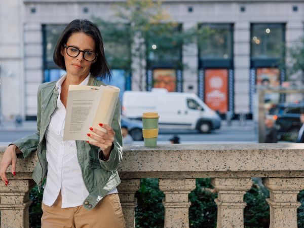 Donna rilassata che si gode un momento di lettura all’aperto in città durante una vacanza studio a New York